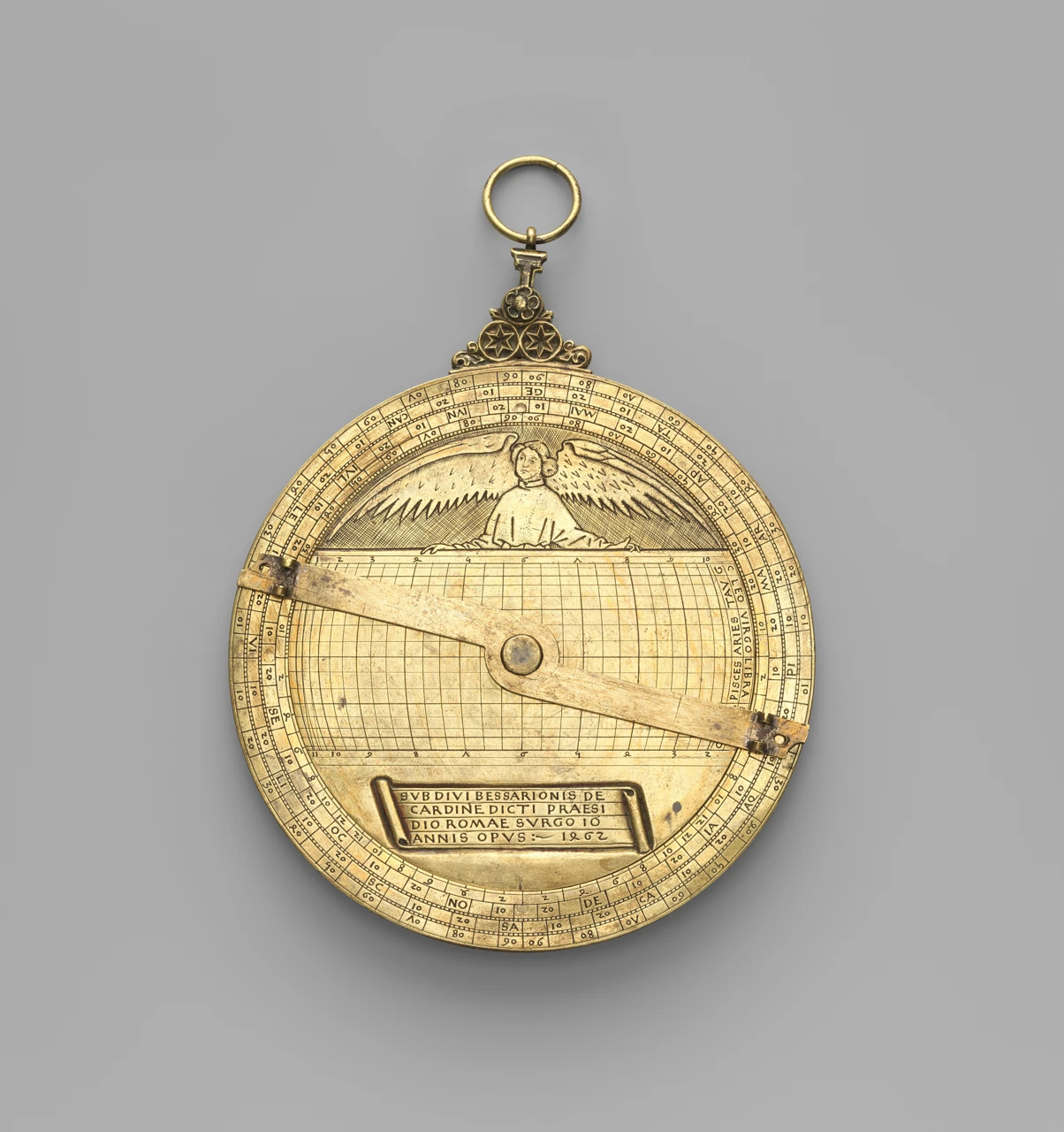 Een ronde metalen schijf met schaalverdelingen, een engel en een lange meetarm.