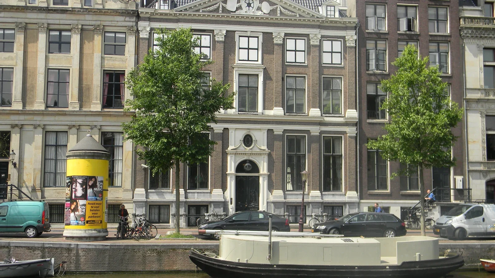 Grachtenpand aan de Herengracht met een boot ervoor.