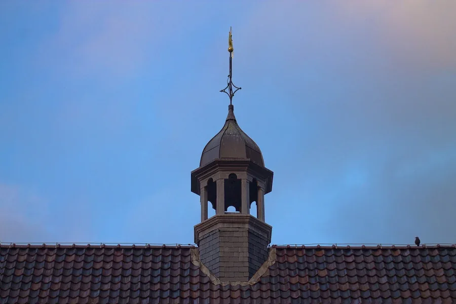 Dach und Türmchen des Rijksmuseum Twenthe vor dem Abendhimmel.