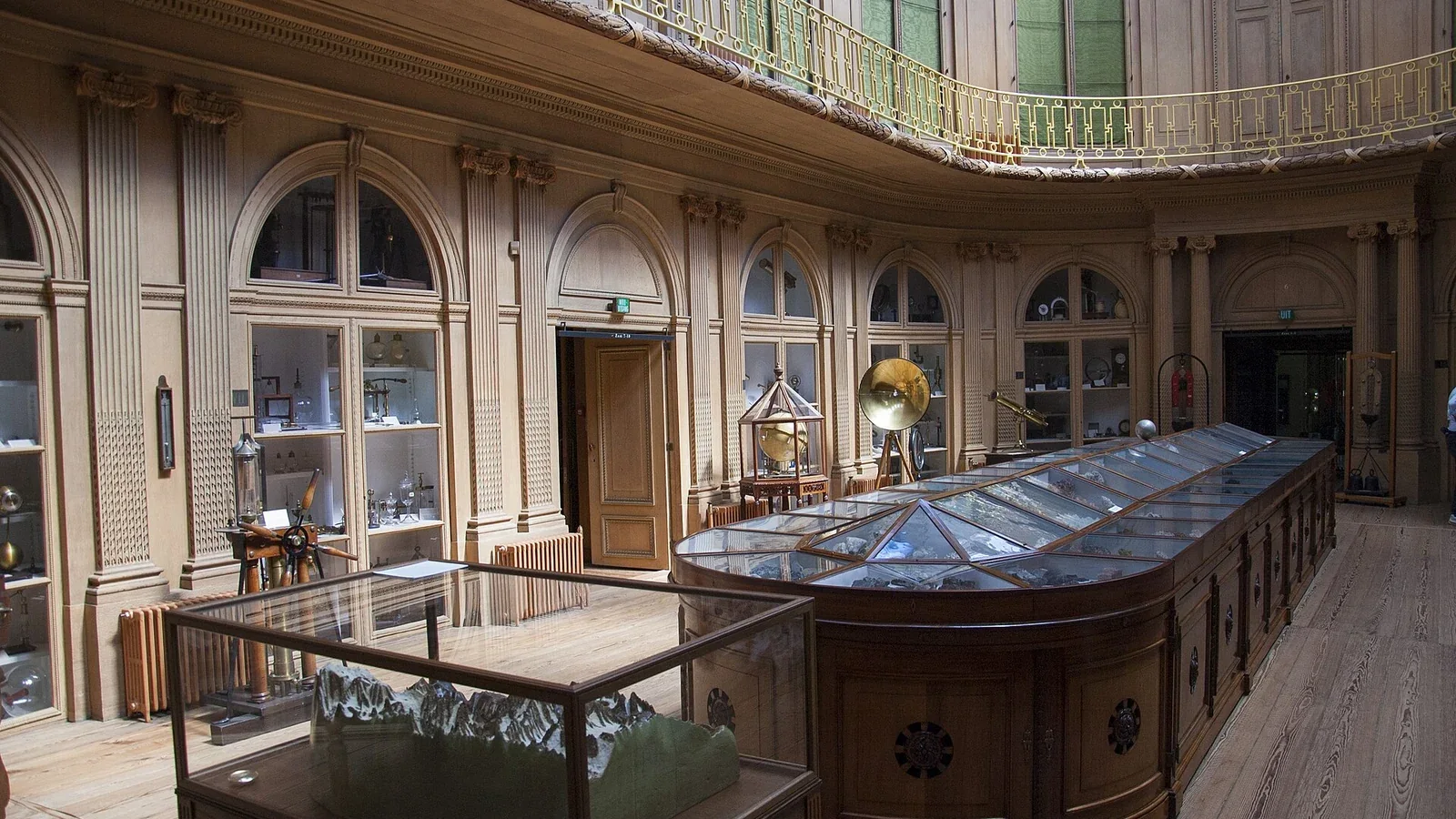 Salle ovale du Teylers Museum avec vitrines et galerie.