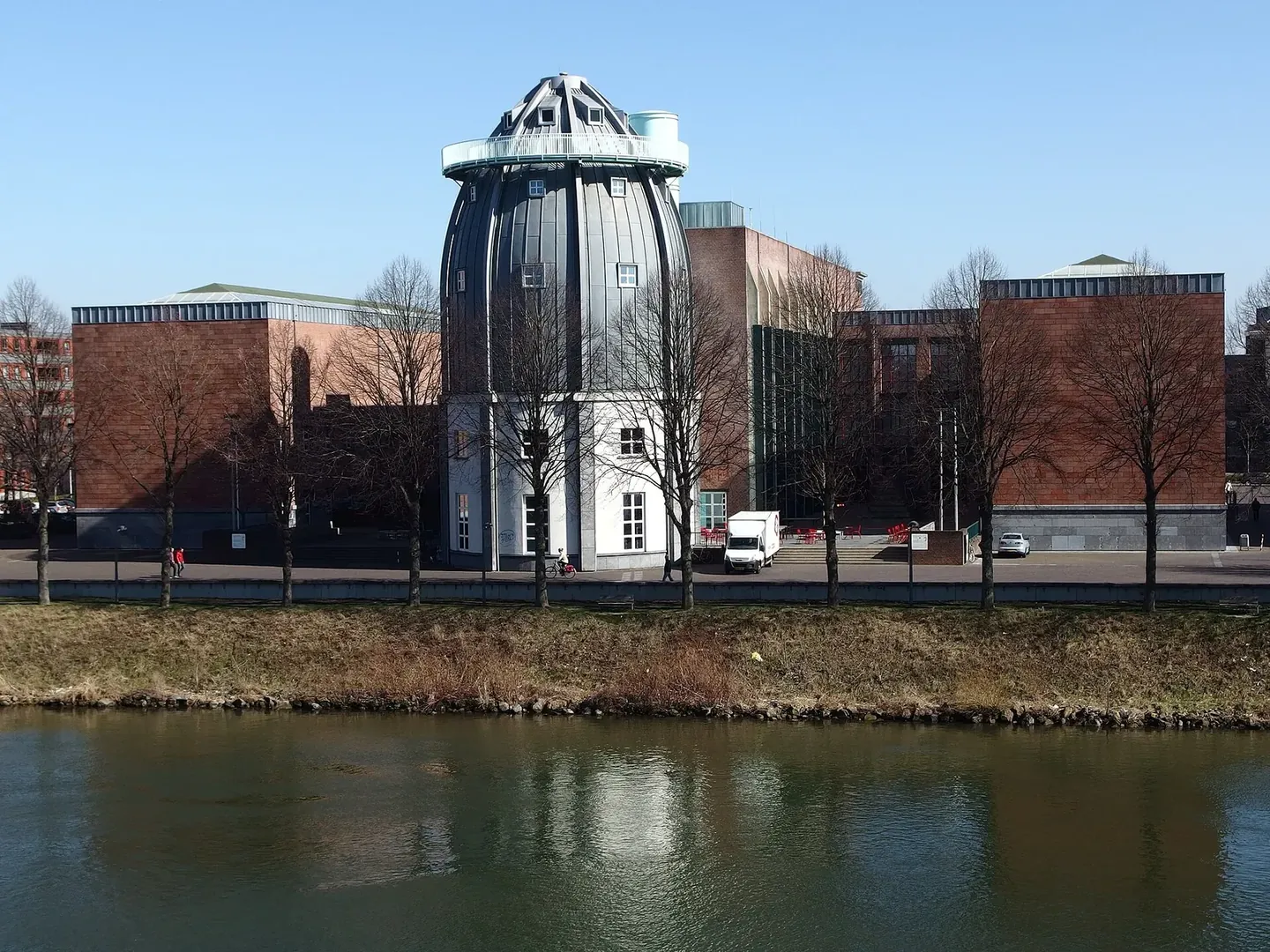 Bonnefanten met koepeltoren en bakstenen museumvleugels achter de Maasoever.