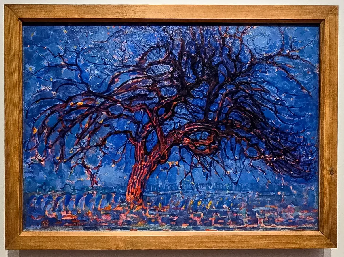 Arbre rouge aux branches largement déployées sur un fond bleu intense.