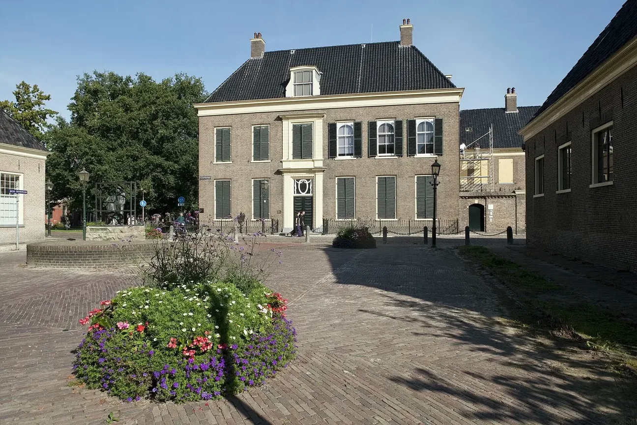 Historische gevel van het Drents Museum aan een plein in Assen.