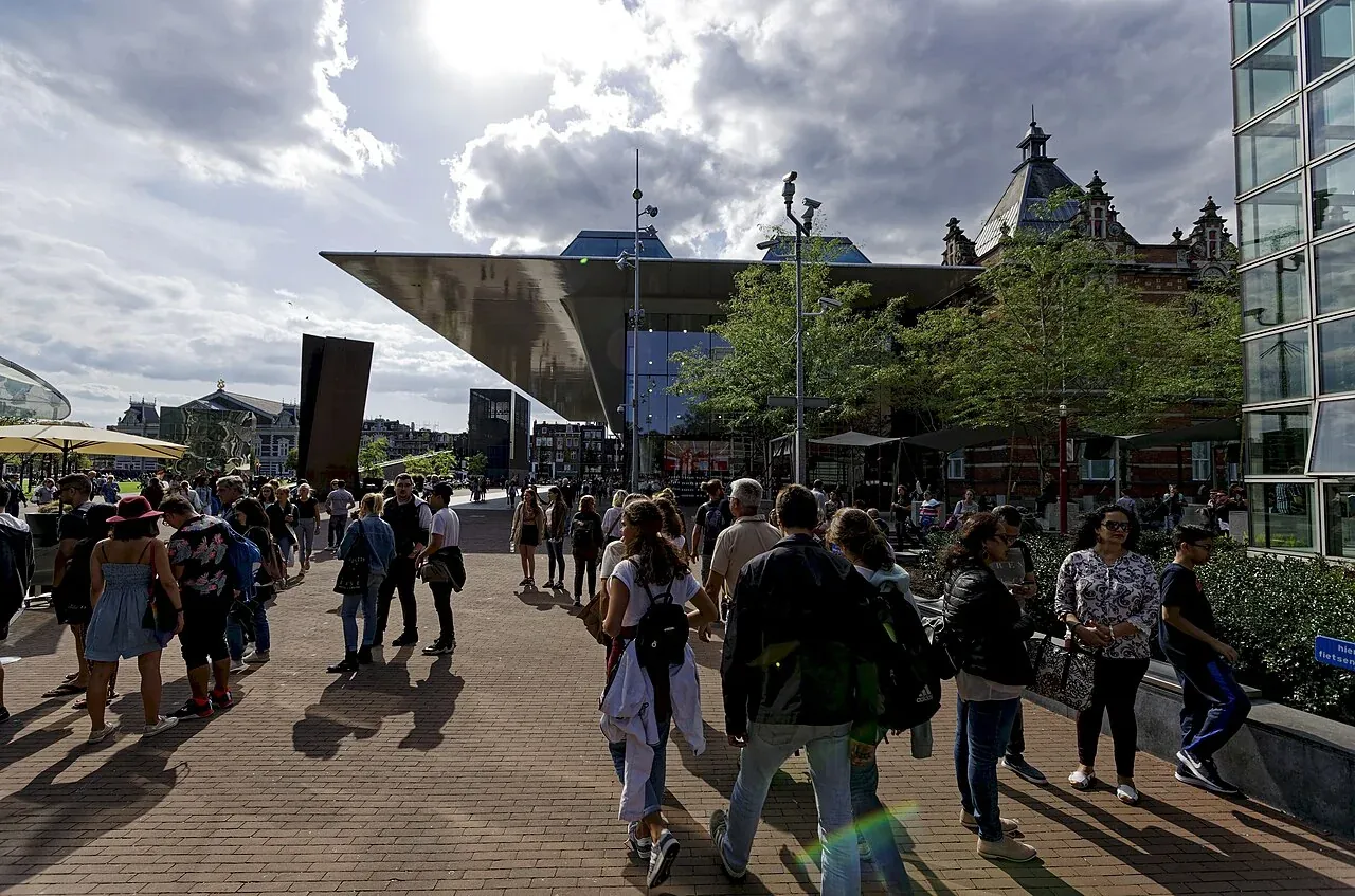 Visitors on Museumplein with the Stedelijk Museum in the background.