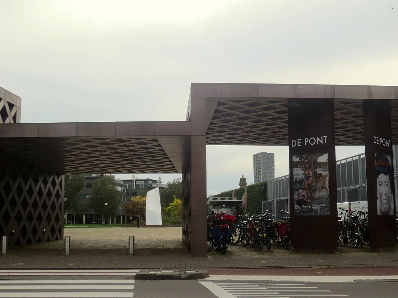 Toegangspoort van De Pont Museum met fietsen en een zebrapad.