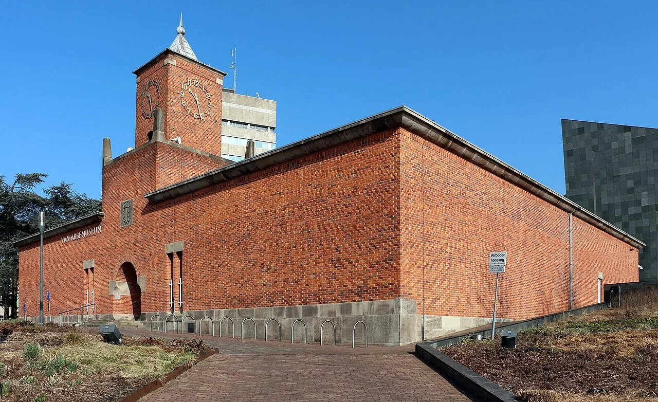 Bakstenen oude museumgebouw met klokkentoren en entree.