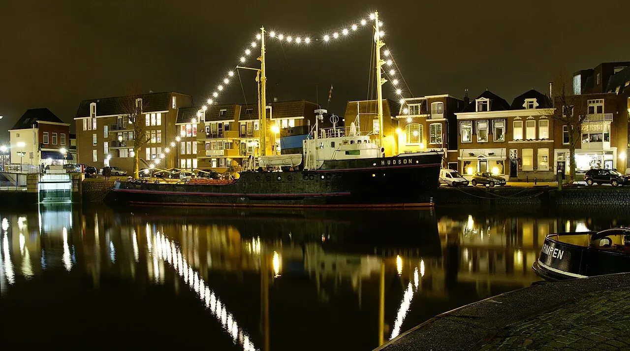Beleuchteter Schlepper Hudson im Hafen von Maassluis bei Nacht.