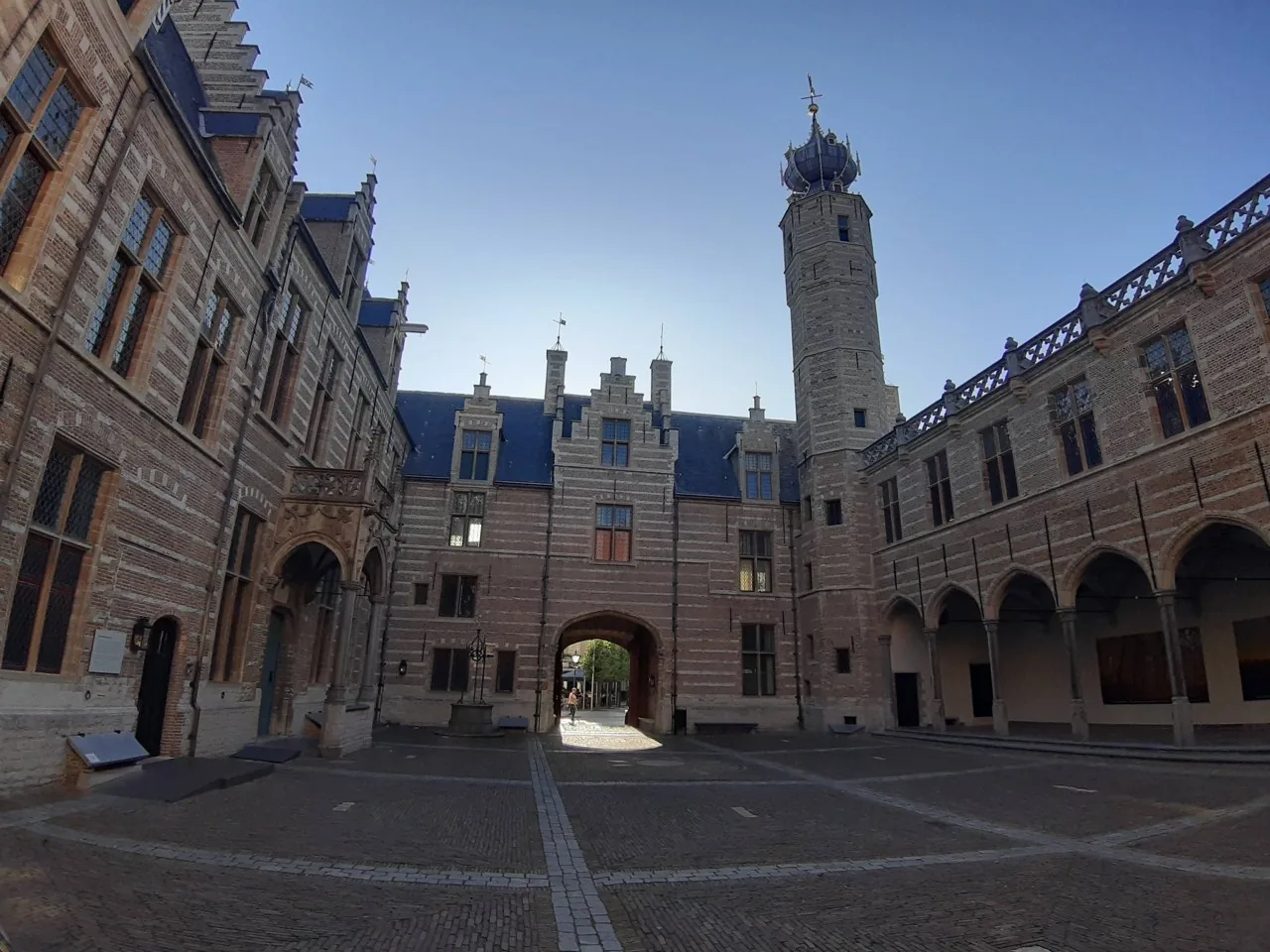 Binnenplaats van het Markiezenhof met galerijen, poort en hoge toren.