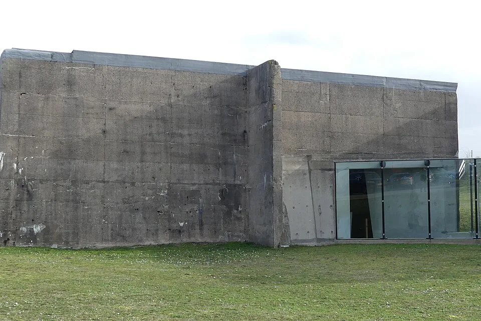Betonnen buitenwand van een caisson met glazen entree bij het Watersnoodmuseum.