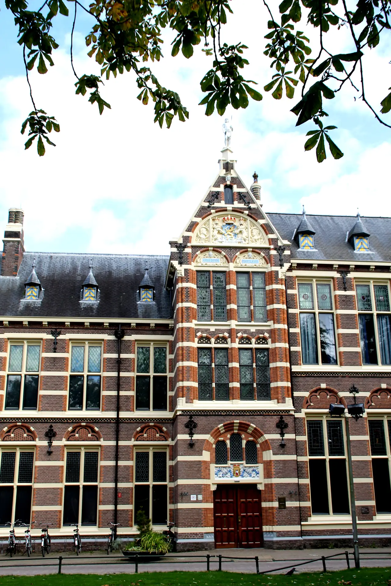Façade en brique du Drents Museum historique sous des branches d’arbre.