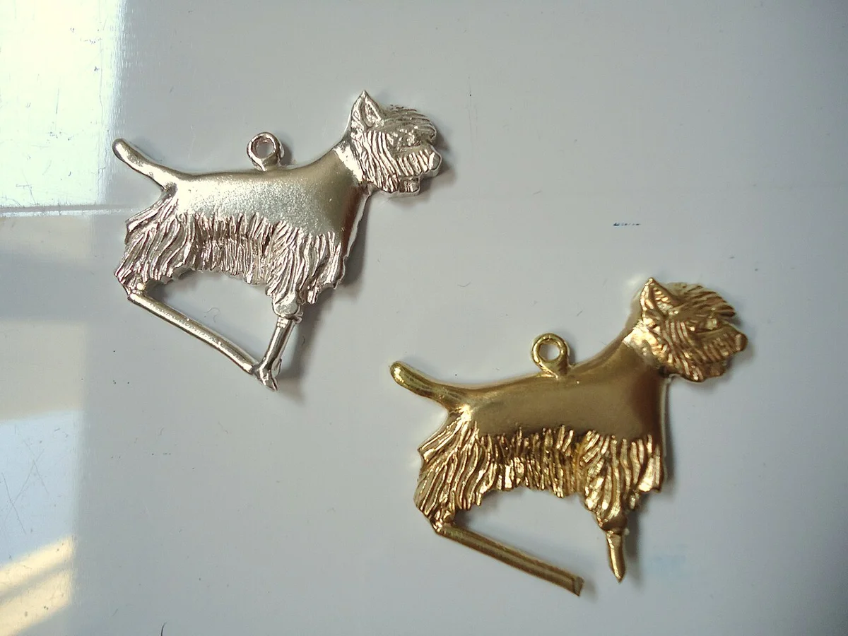 Kleine gietstukken in de vorm van een hond, met nog zichtbare gietkanalen.