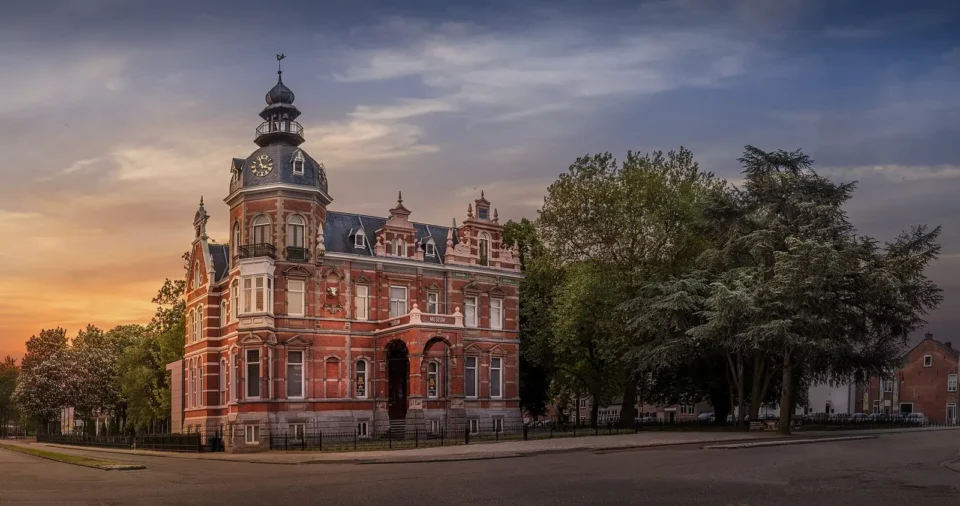 Villa Constance aus Backstein mit Turm im Abendlicht in Oss.
