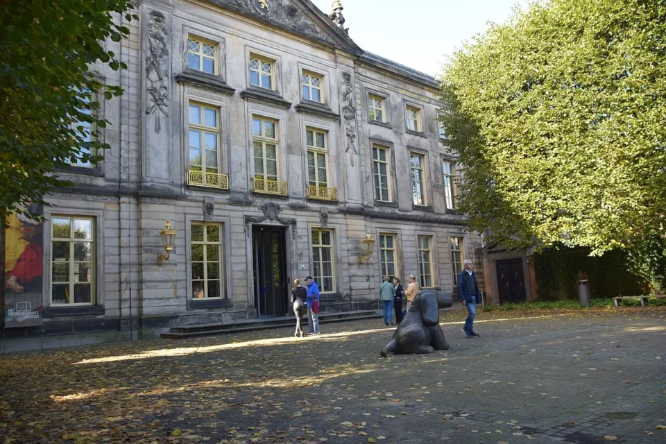 Lichte paleisgevel met hoge ramen aan de binnenplaats van Het Noordbrabants Museum.
