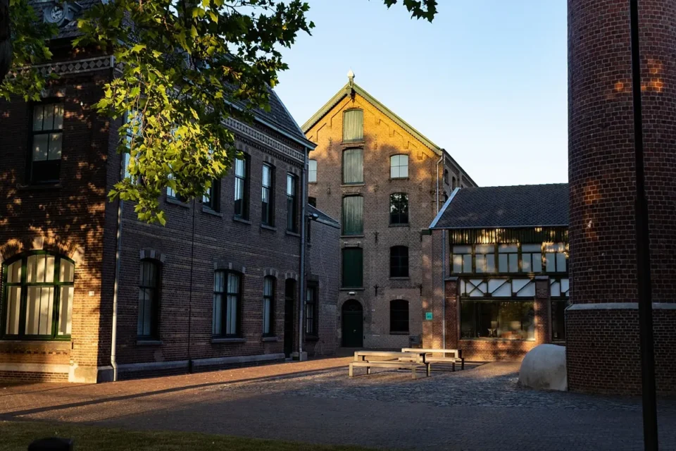 Cour du TextielMuseum entourée de bâtiments industriels en brique.