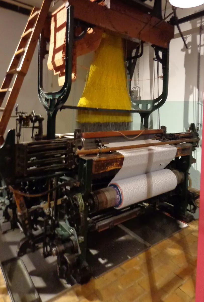 Métier Jacquard historique avec fils et bande de tissu tissé.