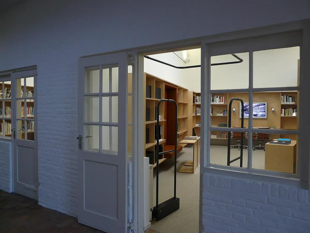 Heller Durchgang mit Fenstern und Türen zu einer Museumsbibliothek.